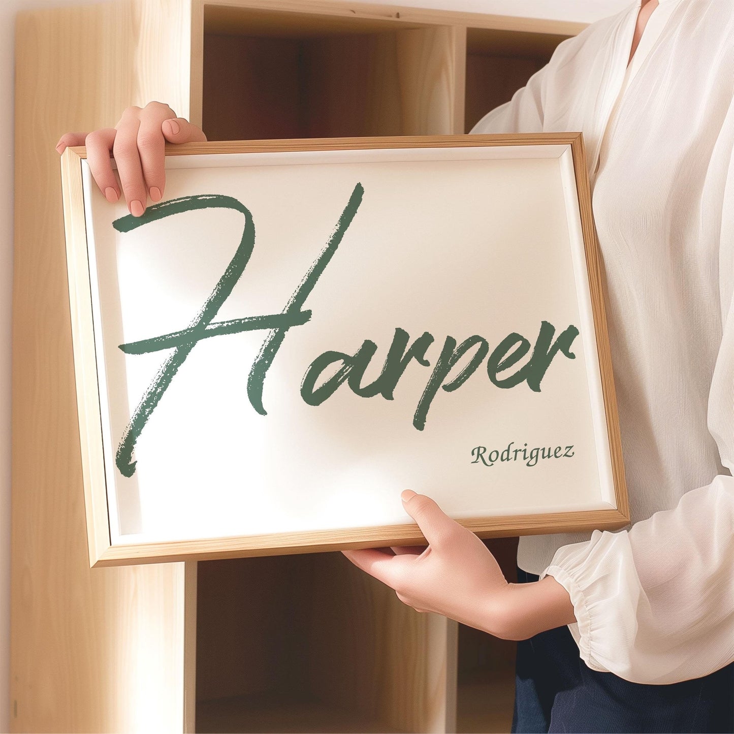 Person holding a framed custom baby name sign with the name Harper Rodriguez in a bold green brush font, suitable for nursery wall decor.