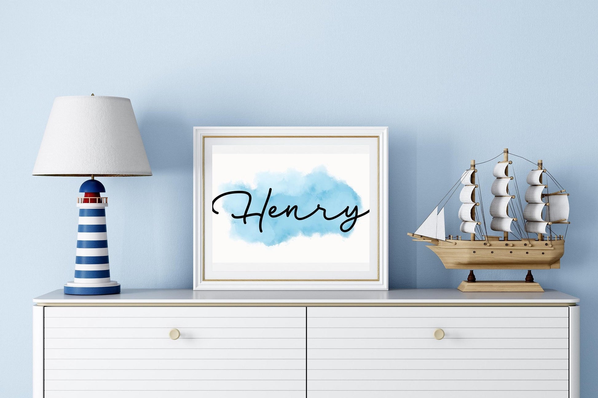 Nursery name sign with Henry in elegant script on blue watercolor background, styled on white cabinet with nautical decor, a charming above crib sign.