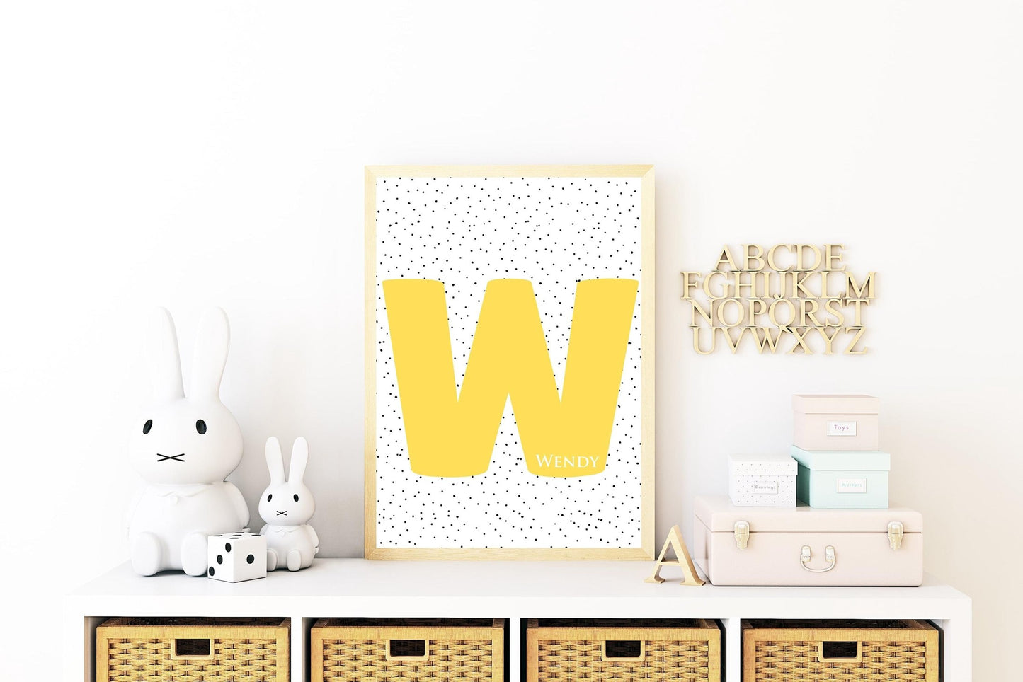 Personalized yellow initial name sign with letter W and dotted background in a nursery setting with toys and decorative accents