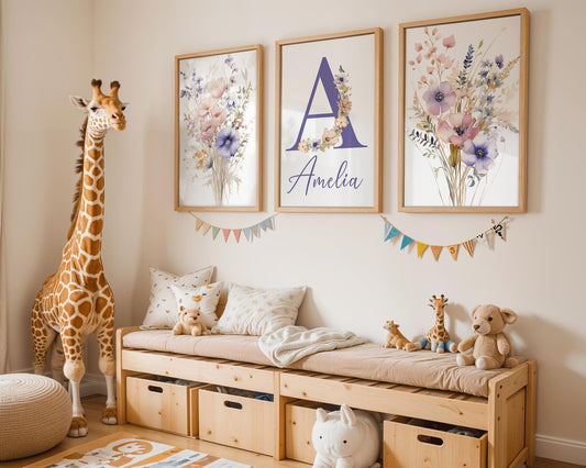 A nursery corner with warm wood furniture. Three floral-themed wall art frames are showcased, with the letter A and a name in purple. Features a giraffe plush toy and soft toys arranged neatly.