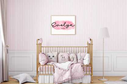 Custom name print of Evelyn Williams on pink watercolor background, hung above crib with pink bedding, a beautiful boho name sign for nursery decorations.