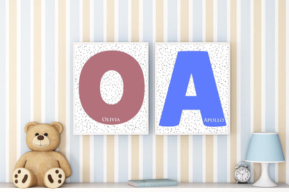 Custom initial name signs featuring letters O and A for Olivia and Apollo, styled with dotted backgrounds in a nursery with teddy bear decor