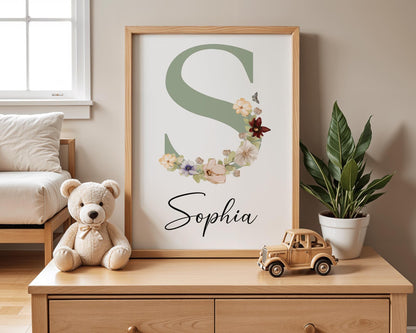 Nursery wall art featuring a green initial adorned with soft floral accents, ideal for boho-themed nurseries or as a custom baby gift.