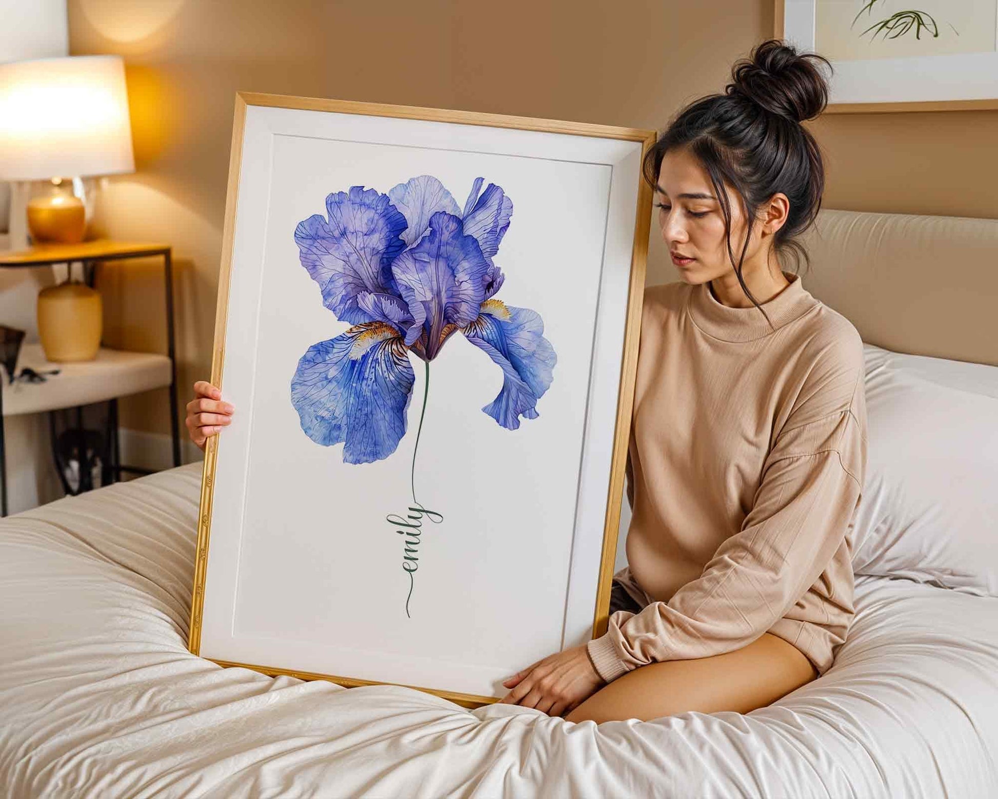 Woman in a calm space holding a framed blue iris flower artwork personalized with the name Olivia showcasing personalized artwork for thoughtful gifting.