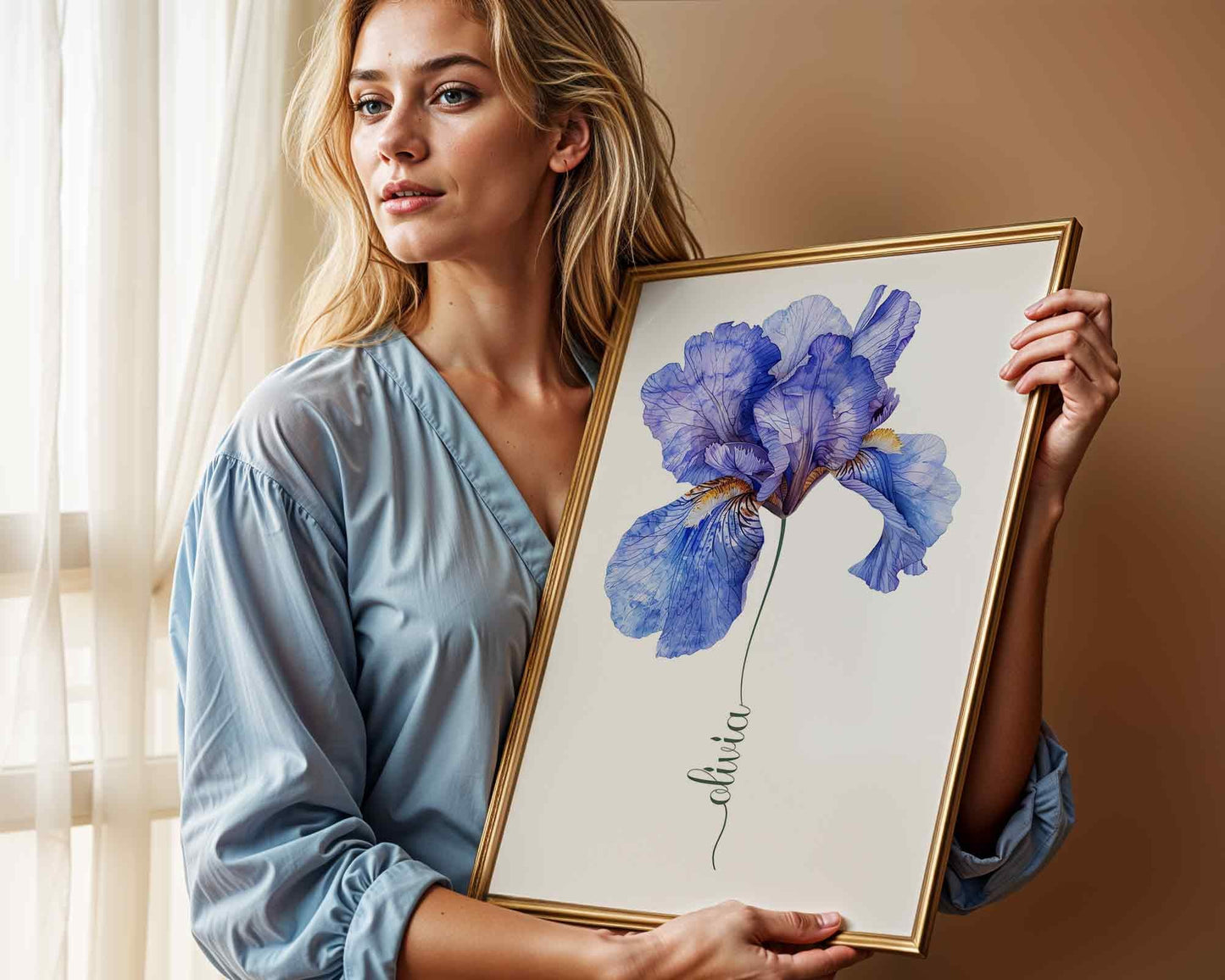 Woman holding a framed blue iris flower artwork personalized with the name Sophia in a cozy living room with soft lighting ideal for personalized home decor.